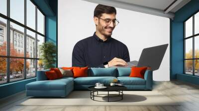 Portrait of young business man standing, holding laptop with happy smile Wall mural