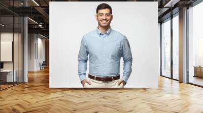 Smart businessman smiling at camera, wearing trendy transparent glasses, isolated on gray background Wall mural