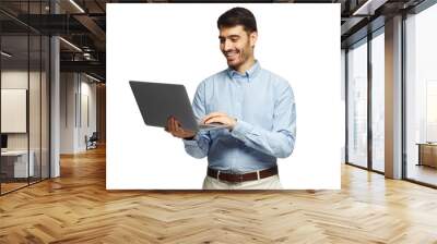 Young businessman using laptop, laughing, standing and smiling Wall mural