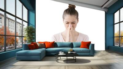 Young european female looking stressed, putting hands together as if she is praying with closed eyes to overcome depression and find solution to problem Wall mural