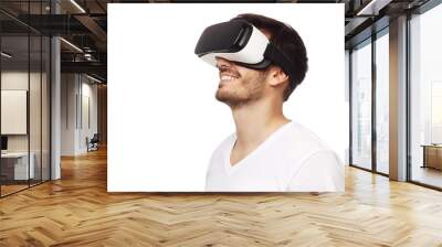 Young happy man smiling while enjoying and experiencing virtual reality with VR headset, isolated on white background Wall mural