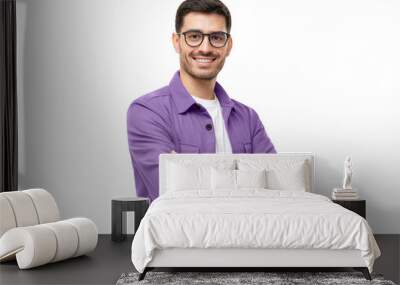 Young hispanic man wearing purple shirt and glasses, looking at camera with positive confident smile, holding arms crossed Wall mural