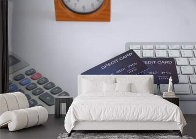 Credit card on computer keyboard with calculator and table clock on white desk. Concept of Online shopping and payment. Wall mural