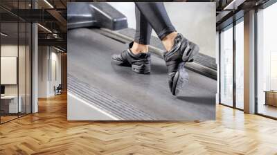 Woman running in a gym on a treadmill concept for exercising Wall mural