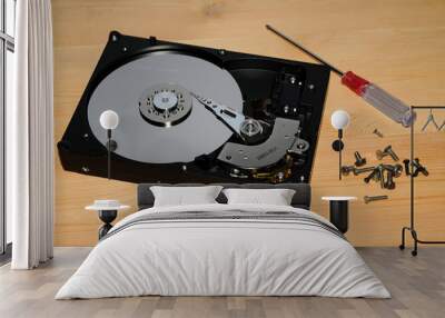 open hard disk drive with screwdriver and screw on wood background Wall mural