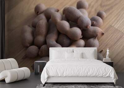 Tamarind, fruits of Tamarindus indica, raw tamarind fruits on wooden background Wall mural