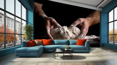 Hands of a man kneading dough on a black background Wall mural