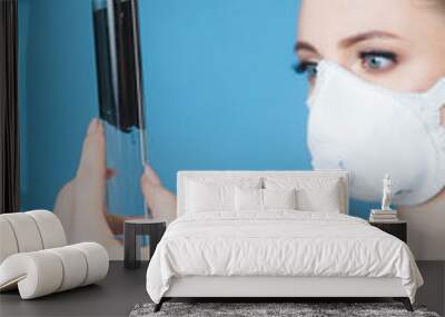 beautiful woman doctor in protective mask against coronavirus on a blue background in the Studio Wall mural