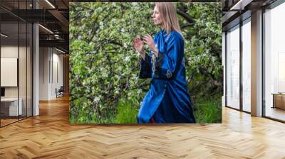 woman practices Chinese gymnastics against of blooming Apple tree Wall mural