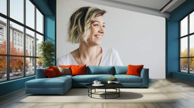 Beautiful young girl with short hair is smiling. Wall mural