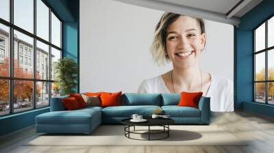 Beautiful young girl with short hair is smiling. Wall mural