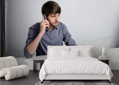 Young man working at laptop Wall mural