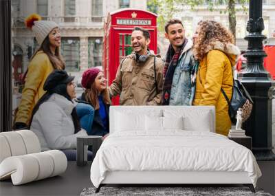 A group of young friends talk and laugh happily in a London street Wall mural