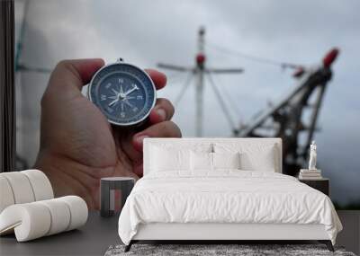 Holding a navigation compass with a harbor atmosphere background Wall mural