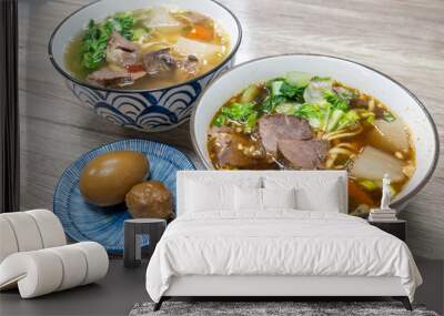 Two bowls of Taiwanese beef noodle soup, an egg and a meatball on rustic wooden table, showcasing a delicious and comforting meal made with fresh ingredients Wall mural