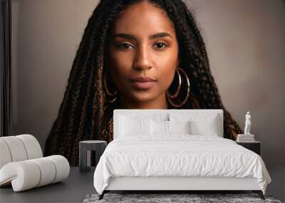 A close-up portrait of a woman with textured locs, adorned with natural jewelry and a serene Wall mural