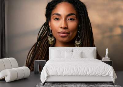 A close-up portrait of a woman with textured locs, adorned with natural jewelry and a serene Wall mural