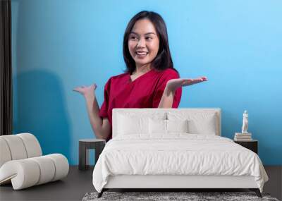 An Asian woman wearing a red dress stands against a light blue background, smiling with her hands raised to the sides in a questioning or cheerful gesture. The image showcases a positive Wall mural