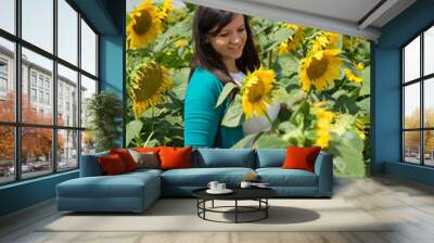 Beautiful girl in yellow field of sunflowers Wall mural