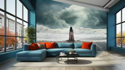 Beautiful woman watches the waves of the sea from the beach Wall mural