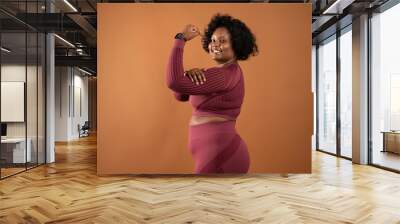 black curvy girl body positive wearing sportswear showing muscles feminist person Wall mural