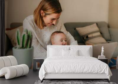 young business mother works from home with her cute baby Wall mural