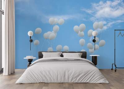 A group of white balloons floating in the sky against the clouds and blue backdrop. A celebration of purity Wall mural