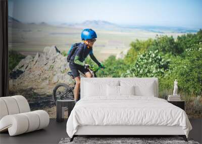 Happy kid boy of 8 years having fun in summer park with a bicycle on beautiful fall day. Active child wearing bike helmet Wall mural