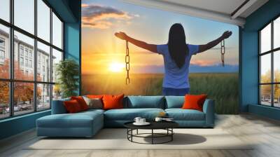 Woman feeling free in a beautiful natural setting, in what field at sunset. Free from chains Wall mural