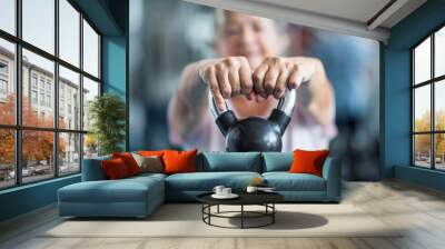 close up of senior holding a weight with his hands in front of the camera at the gym - adult woman working his body to be healthy Wall mural