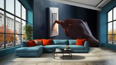 Closeup of a hand switching off a modern light switch, dark room gradually fading to black, ideal for home automation system ads Wall mural