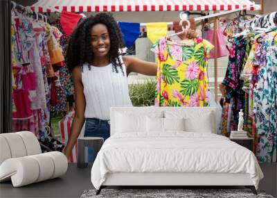 Beautiful african american woman selling clothes at market Wall mural