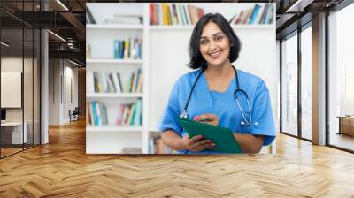 Laughing hispanic nurse wirh file of patient Wall mural