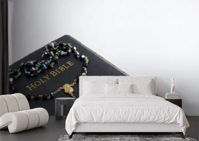 Holy bible with rosary beads on white background Wall mural