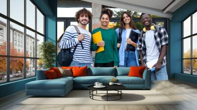 Group of happy and smiling multiracial college students standing in front of university building looking at camera. Wall mural