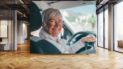 Happy owner. Handsome mature woman sitting relaxed in his newly bought car looking at the camera smiling joyfully. One old senior driving and having fun.. Wall mural