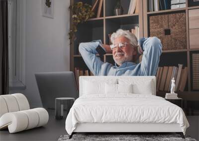 Happy satisfied caucasian mature man rest at home office sit with laptop hold hands behind head, dreamy old senior relax finished work feel peace of mind look away dream think of future success. Wall mural