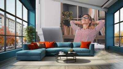 Happy satisfied caucasian woman rest at home office sit with laptop hold hands behind head, dreamy young lady relax finished work feel peace of mind look away dream think of future success concept. Wall mural