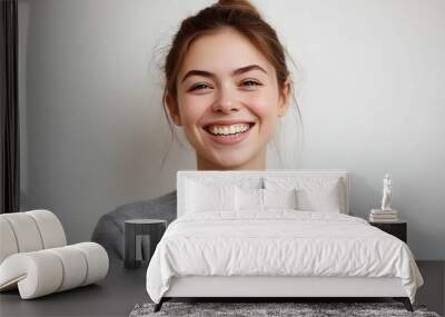 Headshot of good-looking lucky woman with tied hair pure skin and broad smile being happy to watch at camera. Sincere female with beautiful appearance wearing casual clothes isolated over white wall Wall mural