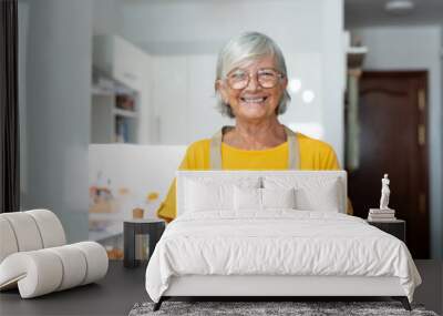 Headshot portrait of cute old one senior showing to camera what she cooked. Mature people at home cooking in the kitchen. Healthy food concept diet holding meatballs. Wall mural