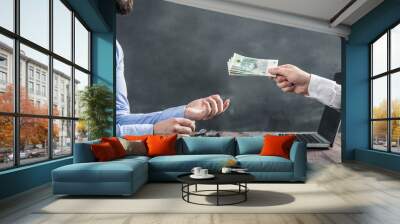 Businessman gets polish cash from the hand coming out of the laptop monitor. The conception of earning money on the internet Wall mural