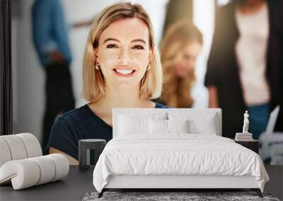 Happy, smiling and confident business woman sitting in a modern office, workspace or workplace. Portrait of a cheerful, joyful and blonde female corporate professional working at a startup company Wall mural