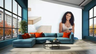 Relaxed woman texting on phone while thinking, planning and dreaming of interior design ideas for new property. Smiling, happy and cheerful homeowner searching or browsing decorations for real estate Wall mural