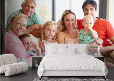 An abundance of love. Portrait of a loving multi-generational family sitting together on a sofa at home. Wall mural