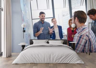 Brainstorming energizes the whole team. Shot of a group of businesspeople listening to a colleagues presentation in the office. Wall mural