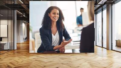 Quick catch up with a coworker. Shot of two young women having a conversation in a modern office. Wall mural