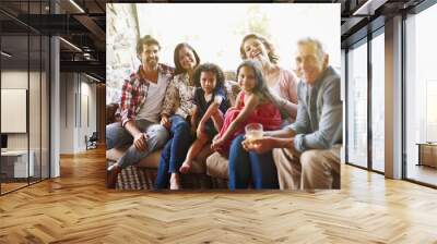 Three generations of laughter and love. A portrait of a three generation family relaxing together at home. Wall mural