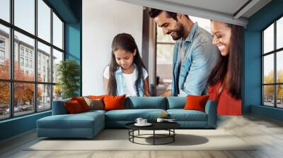 Time to cook, time to bond. Shot of a happy young family preparing a meal in the kitchen together at home. Wall mural