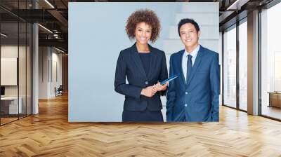 Were eager to grab hold of many more successes. Portrait of two corporate businesspeople standing together in an office. Wall mural