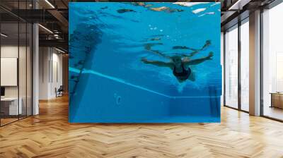 one mature woman or senior swimming alone in a swimming pool and training to be healthy and fitness - active female - under water view Wall mural